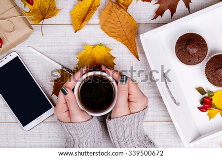 Manicured woman hands holding a cup of warm coffee.