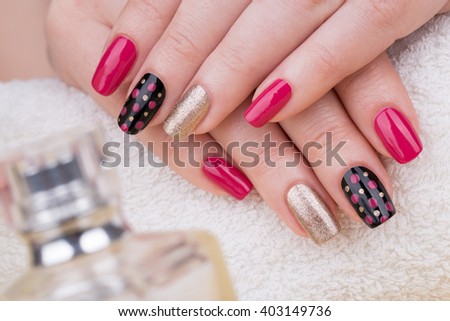 Manicure - Beauty treatment photo of nice manicured woman fingernails. Very nice feminine nail art with nice pink, gold and black nail polish.