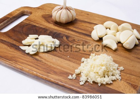 garlic on a wood cutting board over white background