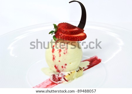 Vanilla ice cream topped with strawberry jam decorated with fresh strawberries