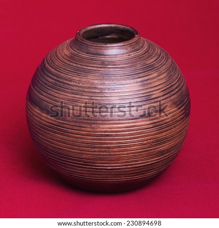 old Hand made Wooden Vase on a red background.