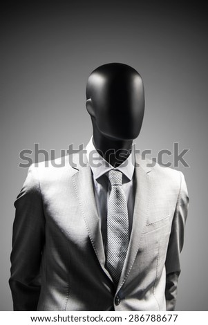 Fashion mannequin in elegant suit over dark grey background. Black White photo