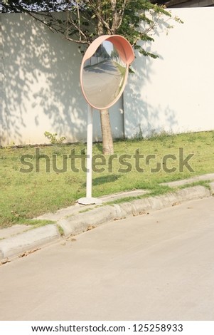 Convex mirror at a street reflecting a barrier