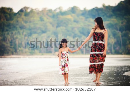 Filmlook tone. Mother and daughter walking on beach