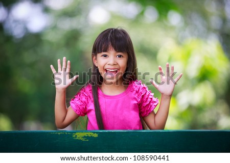 Little girl playing peek-a-boo in the park