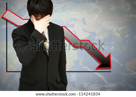 Stressed businessman with low financial graph of global business