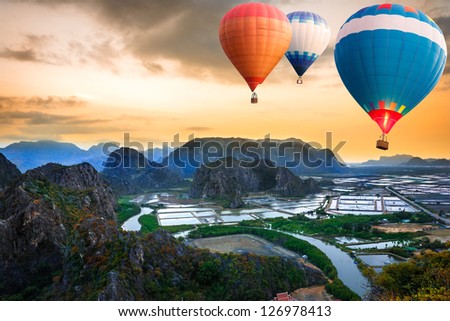 Hot air balloons floating up to the sky over mountain