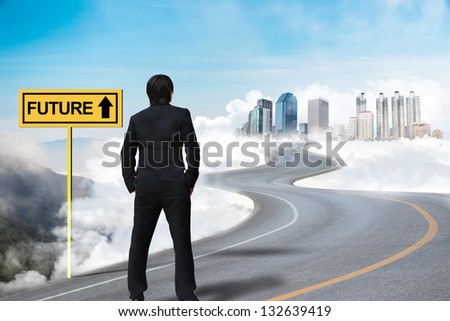 Businessman standing on the empty road and watching the future city on the cloud
