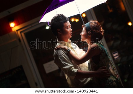 Couple under umbrella at night