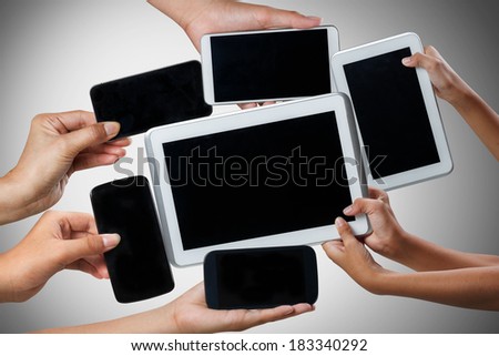 Hands holding tablet computer and mobile phone in different ways, Isolated on grey