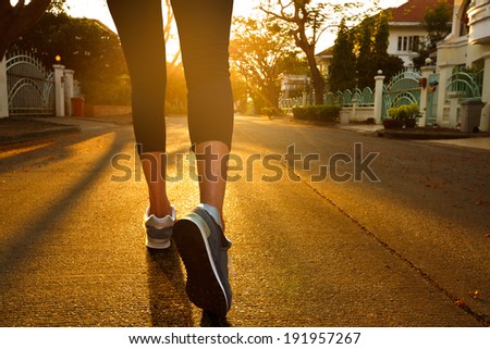 Woman with an athletic pair of legs going for a jog during sunset