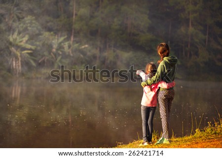 Mother and daughter on the lake, Shot is taken from behind