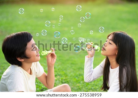 Children in the park blowing soap bubbles