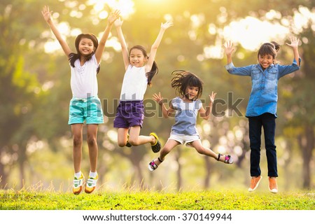 Joyful happy asian family jumping together at outdoor park