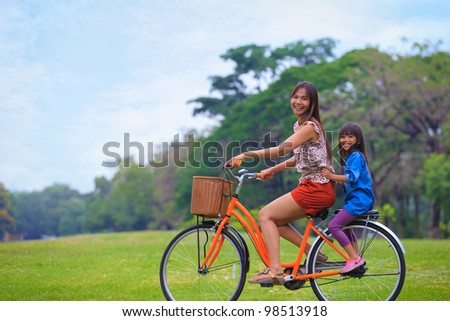 Mother and a daughter cycling bicycle at the park