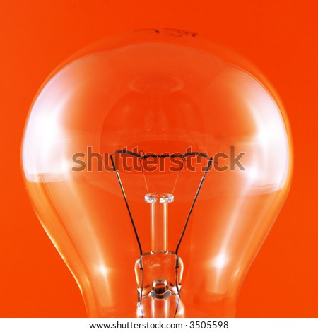 close-up of a clear light bulb on a red background