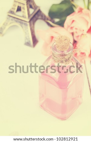 Rose essential oil, perfume with bouquet of pink roses and Eiffel Tower in vintage style