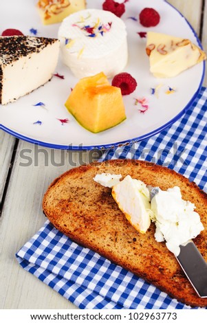 Breakfast - bread, variety of white cheese on a plate with fruits