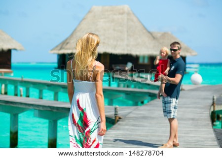 Family of three having tropical vacation in water villa at Maldives