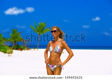 Beautiful bikini model with well shaped body posing on tropical beach at Maldives