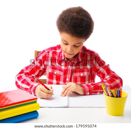 African American school boy focused doing homework, exam, taking test. Concept of education. Isolated, over white background, with copy space