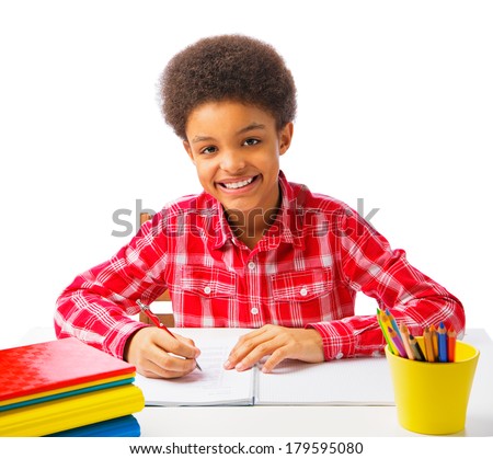Happy smiling African American school boy doing homework, exam, taking test. Concept of education. Isolated, over white background, with copy space