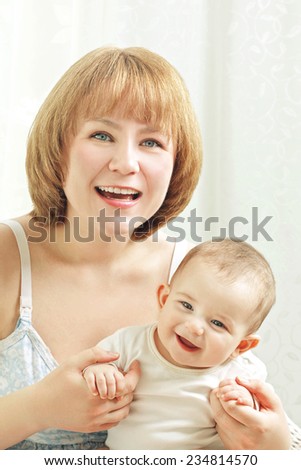 Portrait of mom holding happy smiling baby. Concept of togetherness and love. Positive emotion expression.