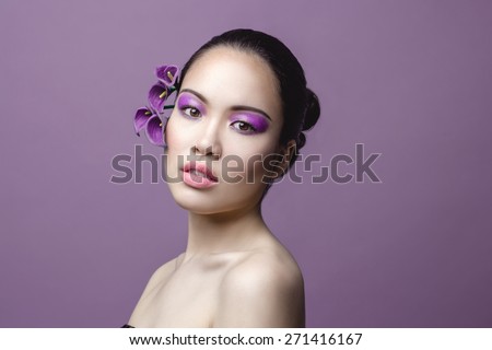 Asian beautiful woman, fashion model, with creative lilac beautiful make up, wet look, closed eyes
