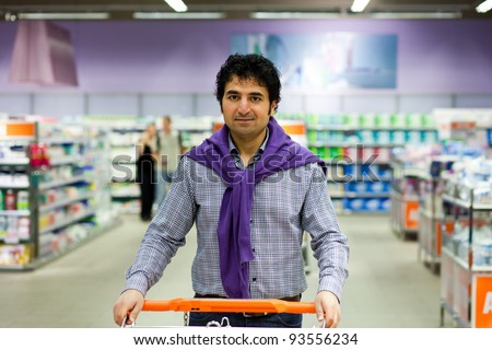 Man with a cart shopping in a consumer goods section