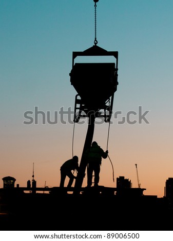 Silhouette of builders doing construction work at sunset