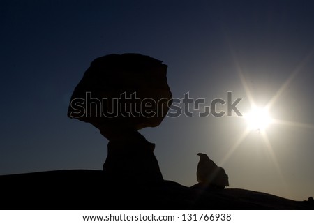 Rocks shaped as a mushroom and a chicken with a sun in the background in the white desert, Oasis area, Egypt.
