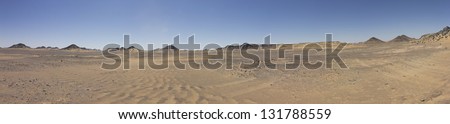 Black desert panorama with desert mountains on the horizon, Oasis area, Egypt. Black rock was created by the volcanic activity long time ago
