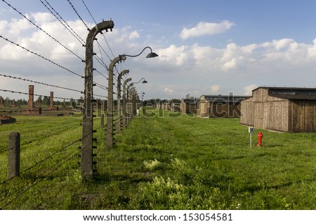 AUSCHWITZ, POLAND - AUGUST 24: The cheap wooden accommodation and barbed wire fence of Auschwitz II-Birkenau, a former Nazi extermination camp and now a museum on August 24, 2013 in Oswiecim, Poland