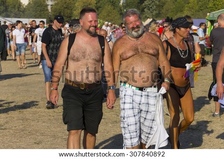 PRAGUE - AUGUST 15, 2015: Two hairy man without tshirts holding hands at Letna park on the fifth Gay Prague Pride 2015