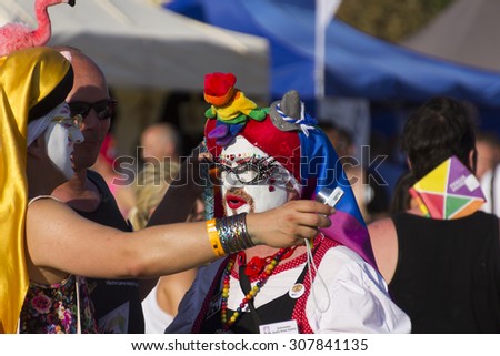 PRAGUE - AUGUST 15, 2015: An older man at Letna park being dressed as a drag queen and taking photos with others at the fifth Gay Prague Pride 2015