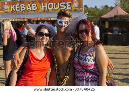 PRAGUE - AUGUST 15, 2015: Two girls with a sexy young man in borat style tiger mankini and a white angel mask at Letna park on the fifth Gay Prague Pride 2015
