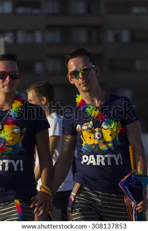 PRAGUE - AUGUST 15, 2015:  A gay couple holding hands at Letna park on the fifth Gay Prague Pride 2015 during the outdoor concert