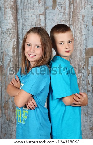 Twin brother and sister posing together in studio