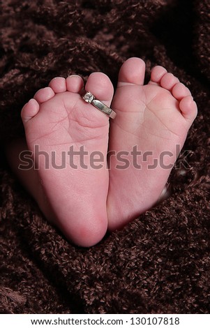 babies feet taken closeup with wedding ring