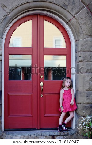 Little girl sad outside house by door