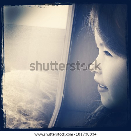Little girl looking out window on boat