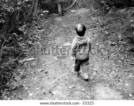 Boy walking in the woods with his father, black and white