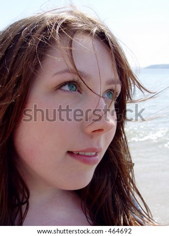Young woman with green eyes, hair blowing in the wind