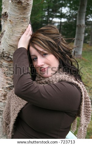 Young woman outdoors Posing by a tree