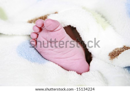 babies foot taken closeup with blanket around it