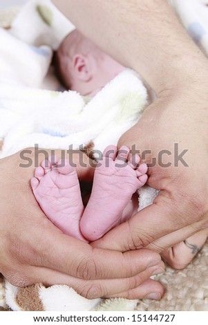 babies foot taken closeup in father\'s hands