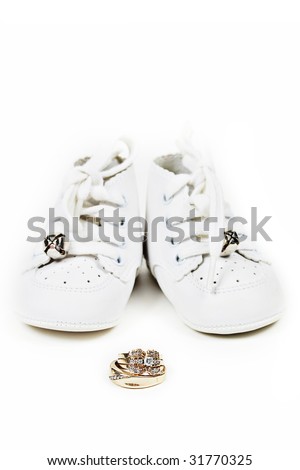 stock photo Baby shoes and wedding ring set