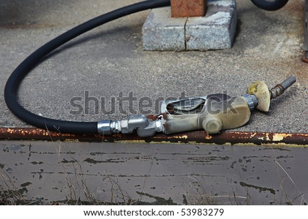Old gas pump on the ground with hose