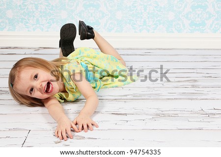 Adorable little girl making funny faces in studio