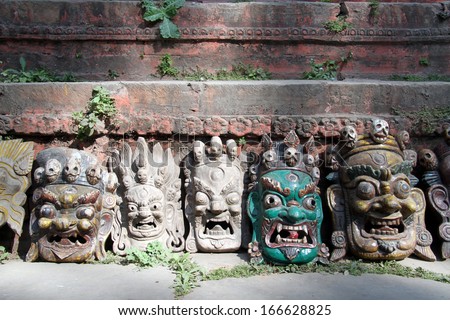 Traditional masks near wall of temple on the Durbar square in Khatmandu, Nepal